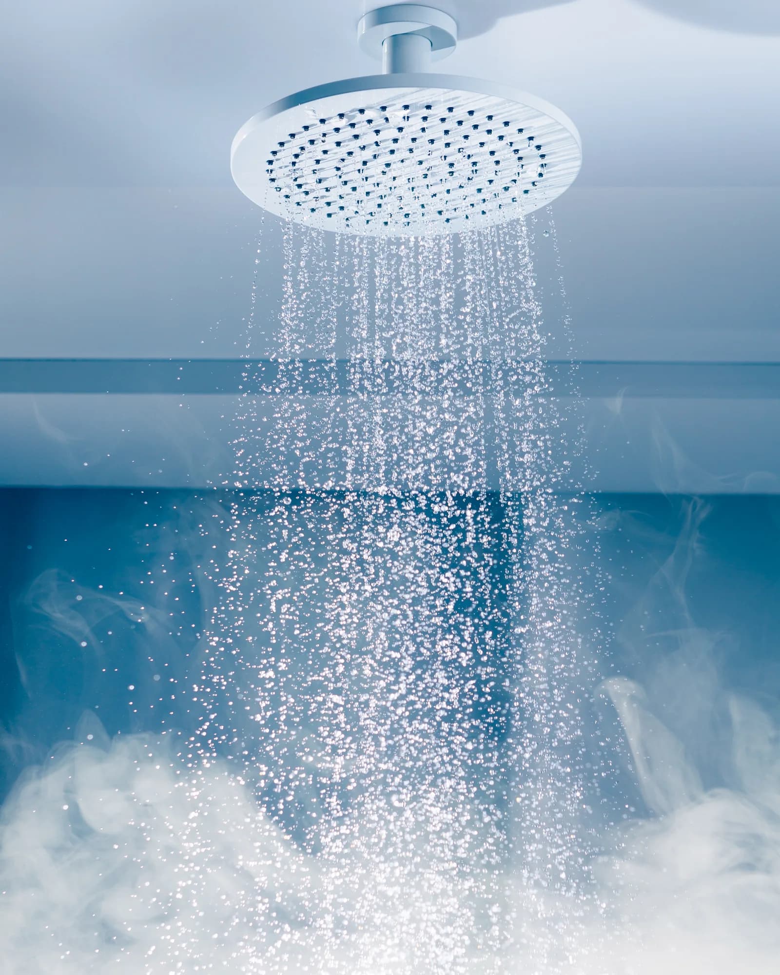 Ducha de lluvia tipo spa con agua y vapor en un baño de hotel